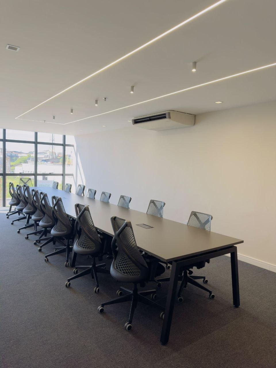 Sala de reunião com mesa longa e cadeiras
